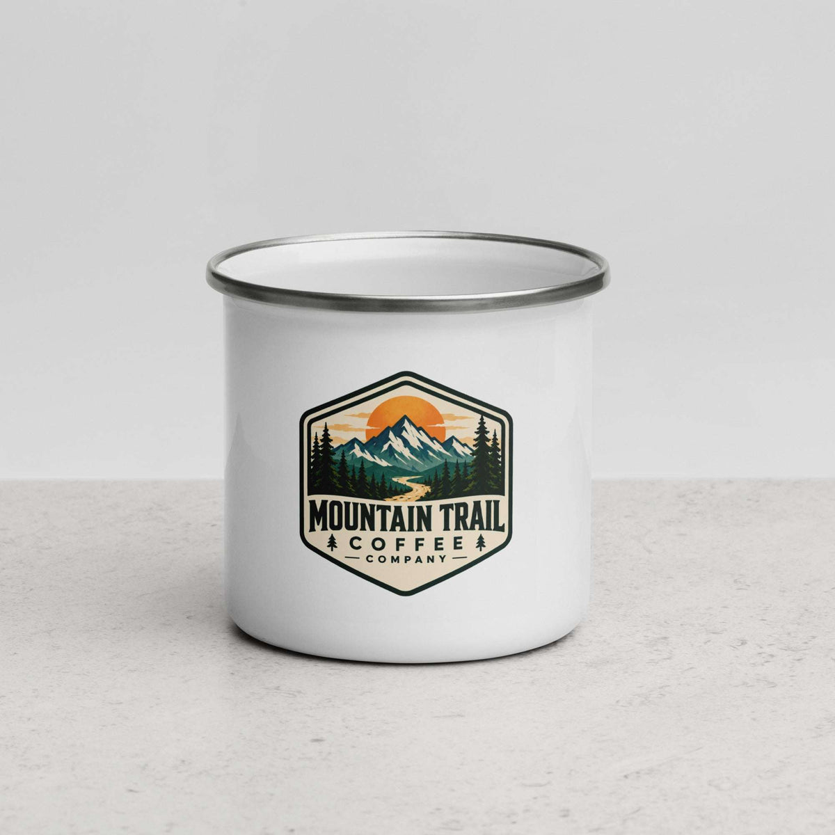 Enamel Mug with a white enamel body, silver rim, and colorful mountain trail coffee company badge on the front.